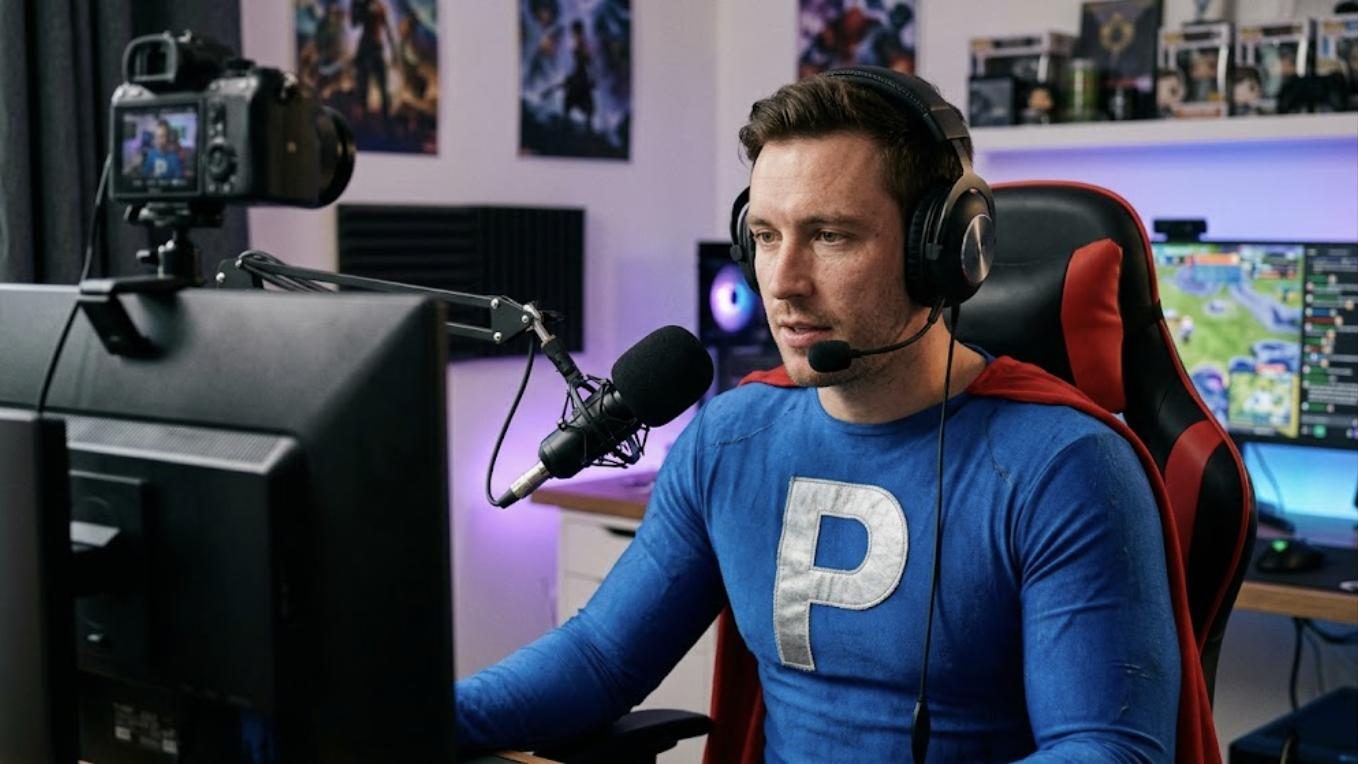 Superhéroe de Patillero con la P en el pecho haciendo un directo en Twitch